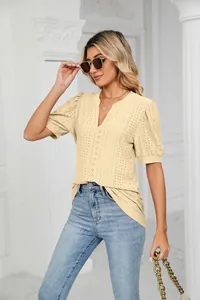 Close-up of elegant V-neck blouse with intricate eyelet embroidery and puff sleeves.