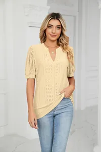 Close-up of beige eyelet V-neck blouse with puff sleeves in an elegant interior setting