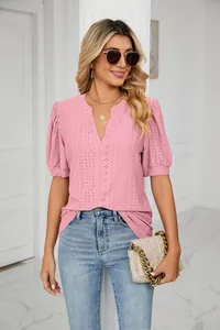 Detailed view of women's pink V-neck eyelet top with puff sleeves on model.