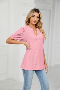 Detail of pink V-neck top featuring delicate eyelet embroidery and puff sleeves.