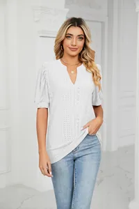 Close-up of white eyelet embroidery and puff sleeve detail on V-neck top