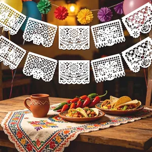 Traditional white Mexican papel picado banner hanging above a festive taco party table