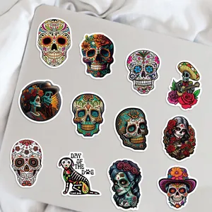 Vista detallada de pegatinas mexicanas del Día de los Muertos sobre un portátil.
