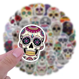 Detailed view of a vibrant Day of the Dead sugar skull graffiti sticker held by a hand
