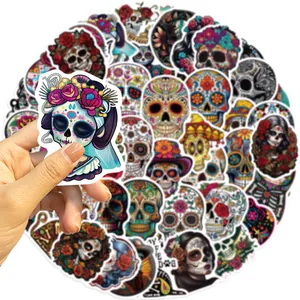 Detalle de una mano sosteniendo una pegatina impermeable de calavera mexicana de azúcar.