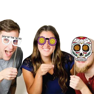 Three people holding Mexico Day of the Dead themed photo booth props for party celebration