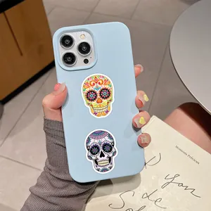 Detailed view of vibrant Day of the Dead sugar skull stickers on a smartphone case