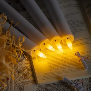 Close-up of four warm glowing LED flameless electronic candles placed on a vintage book