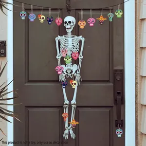 Life-sized hanging skeleton with colorful Mexican sugar skull ornaments on a dark door