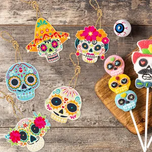 Festive Day of the Dead skull hanging decorations and party supplies on a rustic wooden background