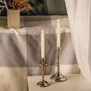 Realistic LED electronic candles with gold and silver holders in a cozy home decor setting.