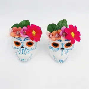 Pair of Day of the Dead sugar skull ornaments with colorful floral headbands for party decor