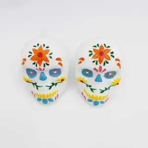Detail view of two colorful painted sugar skull hanging decorations for Day of the Dead