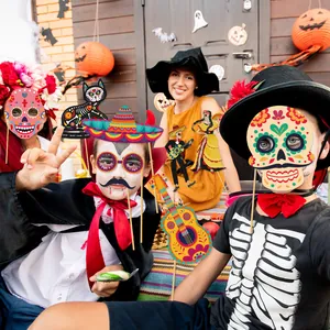 Vibrant Day of the Dead paper photo booth props held by people at a festive party scene