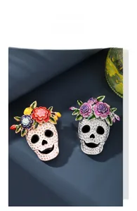 Detailed view of Halloween skull brooches with colorful enamel flowers and crystals.