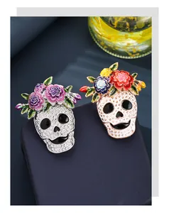 Detail of two floral Halloween skull brooches with enamel flowers and sparkling crystal accents