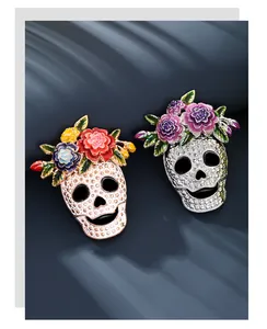 Detailed view of Halloween skull brooches decorated with colorful enamel flowers.
