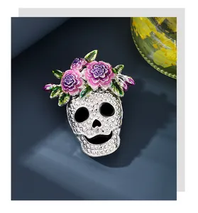 Close-up of Halloween skull brooch with purple enamel flowers and white rhinestones