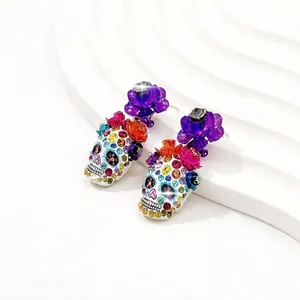 Detailansicht bunter Strass-Totenkopf-Ohrringe mit leuchtend violetten Blumenakzenten
