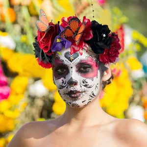 Close-up of Day of the Dead headband with red roses and orange butterflies on model.