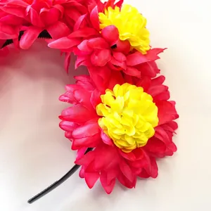Detail macro view of vibrant red and yellow artificial marigolds on festival headband