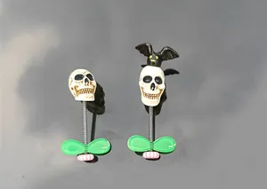 Detail view of Halloween skull and bat car bobblehead ornaments with spring bases.