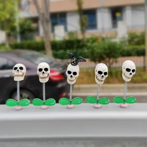 Five Halloween skull bobblehead car dashboard ornaments with spring and leaf base