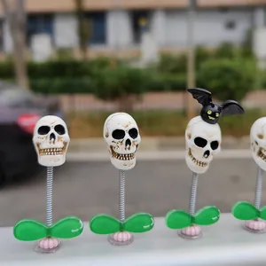 Detailed view of Halloween skull bobblehead car ornaments with metal springs.