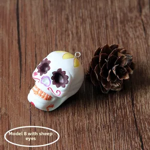 Detailed view of a white resin Halloween skull charm featuring an integrated eye screw