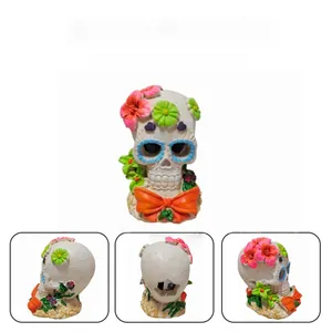 Detailed multi-angle views of a floral skull aquarium ornament with orange bow