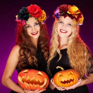 Due donne con fasce floreali colorate di carnevale che tengono zucche intagliate