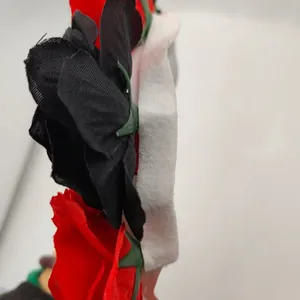 Close-up detail view of red and black fabric roses on a Halloween ghost bride mask