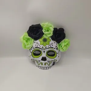 Close-up detail of green and black fabric roses on a decorative Mexican skull mask