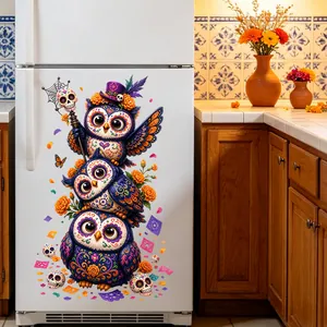 Detail of Day of the Dead owl stickers applied to a white refrigerator in a kitchen.