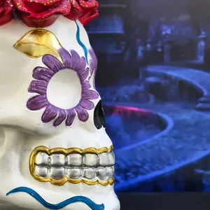 Close-up detail of hand-painted resin bride skull with red roses for Halloween decor