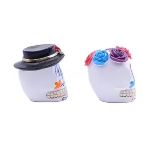 Detail view of colorful Day of the Dead resin sugar skull figurines with flowers
