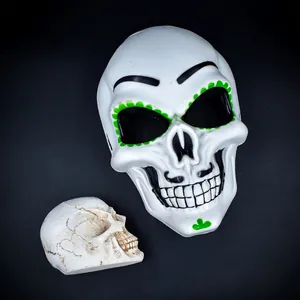Close-up of Mexican Day of the Dead skull mask with green accents for Halloween parties.