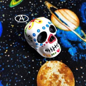 Close-up detail of a white resin sugar skull with colorful floral patterns for DIY crafts.