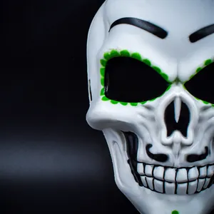 Close-up detail of Mexican Day of the Dead skull mask with green floral eye accents