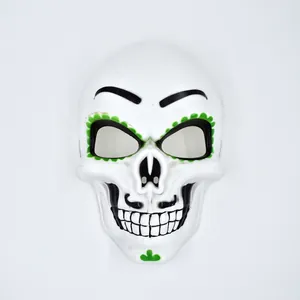 Close-up of Day of the Dead skull mask with green floral patterns and black details