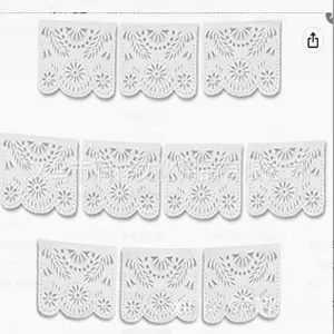 Vue détaillée de fanions Papel Picado blancs en plastique avec découpes florales.