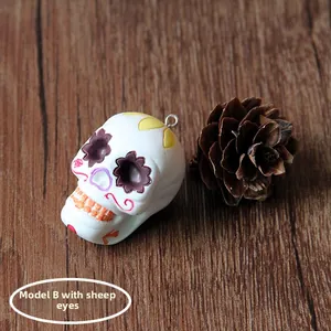Detailed view of a white Halloween sugar skull resin charm featuring a metal eye pin.