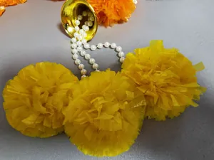 Primo piano di ghirlanda di calendula gialla con campanella dorata e perle bianche.
