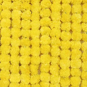 Gros plan de guirlandes denses de fleurs de souci artificielles jaunes décoratives.