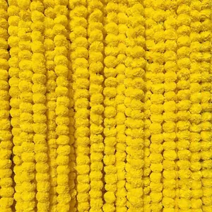 Macro view of dense yellow artificial marigold flower garlands for festival decor