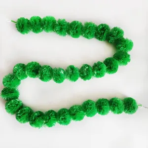 Detailed macro view of a long green plastic marigold pom-pom garland for festive party decor