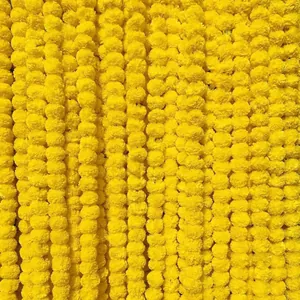 Close-up of bright yellow artificial marigold flower garlands for festive Indian decor