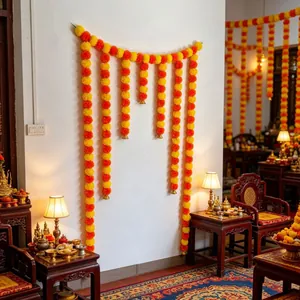Vibrant orange and yellow marigold garland hung on a wall for festive indoor decoration.