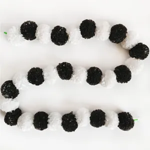 Macro view showing the texture of black and white marigold garland on white background