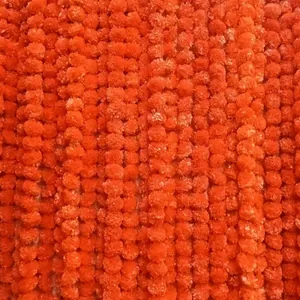 Detail shot of vibrant orange artificial marigold flower garlands for festival decor